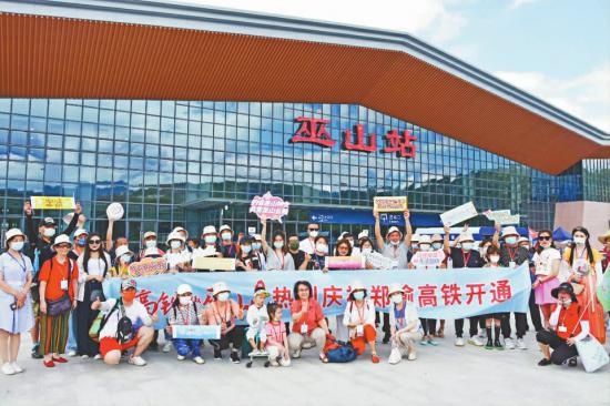 来自成都、重庆、郑州等地的旅行商在巫山站前合影。